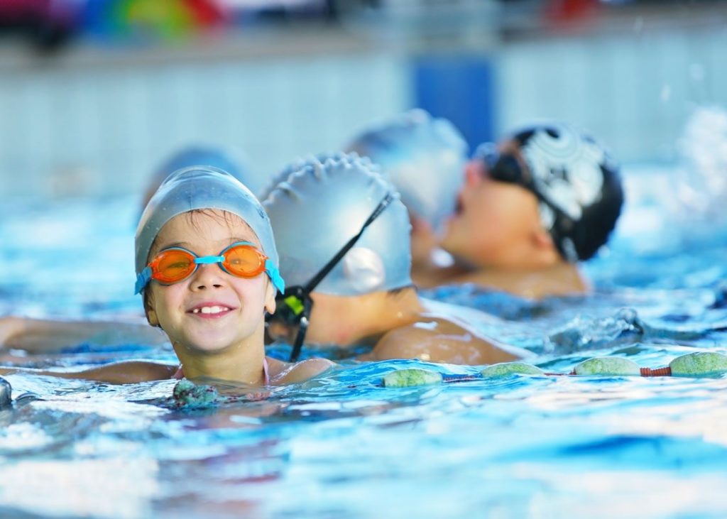 Enfants dans une piscine suivant un cour aquatique